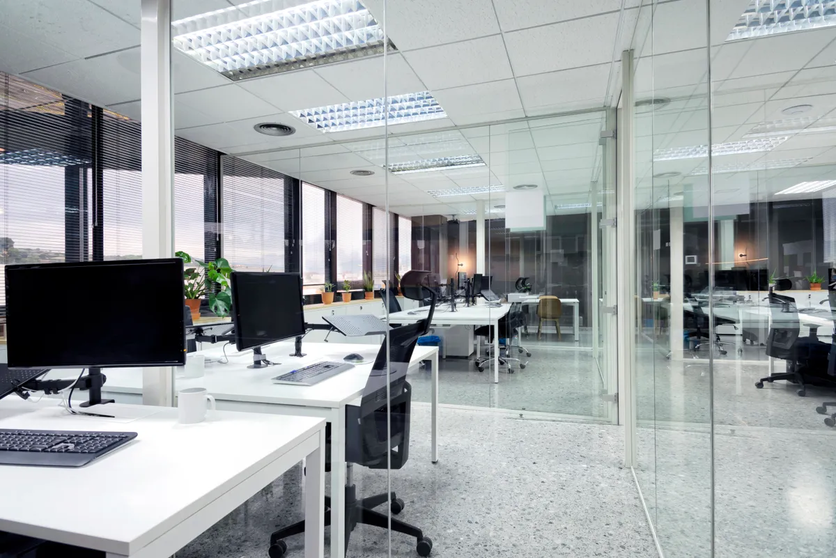 Modern Leeds office interior with overhead linear lighting, glass partitions and open-plan desking installed by Martin Day Commercial Electricians